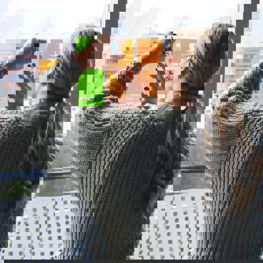 Vrouw die post-it beschrijft, die op het raam is geplakt.