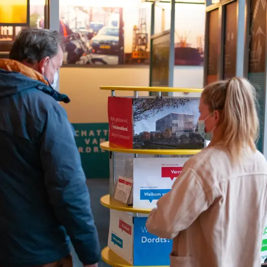 Kaartjes op een tafel waarover twee mensen een gesprek voeren